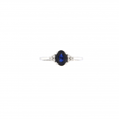 Anello in oro bianco 18kt con zaffiro blu ovale 7x5mm e tre diamanti G VS1 per lato